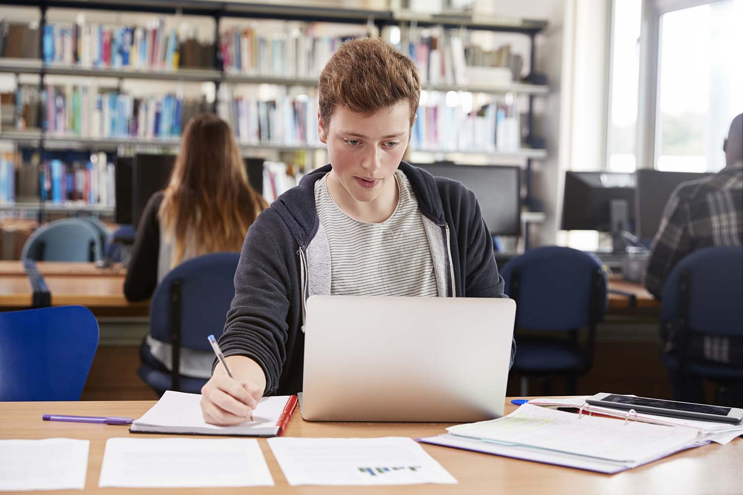 male-student-working-at-laptop-in-college-library-P5ENWP7.jpg